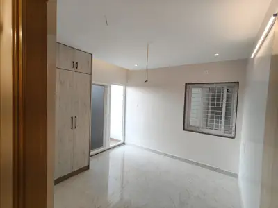 Second bedroom of the Elite Homes 3 BHK sample flat with wardrobe and sliding door to the balcony
